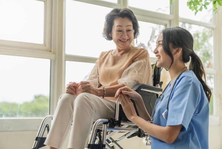 asian-young-caregiver-caring-her-elderly-patient-senior-daycare-handicap-patient-wheelchair-hospital-talking-friendly-nurse-looking-cheerful-nurse-wheeling-senior-patient